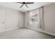 Neutral bedroom features a window dressed with drapes and a ceiling fan at 818 W Earll Dr, Phoenix, AZ 85013