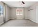 Neutral bedroom features two windows dressed with drapes and a ceiling fan at 818 W Earll Dr, Phoenix, AZ 85013