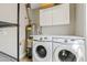 Laundry room features a full size washer and dryer with storage cabinets at 818 W Earll Dr, Phoenix, AZ 85013