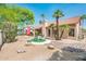 Desert-landscaped backyard with a cozy seating area, framed by mature trees and desert plants at 8977 E Ludlow Dr, Scottsdale, AZ 85260