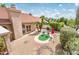 Desert-landscaped backyard features a cozy seating area with desert plants, and a red umbrella at 8977 E Ludlow Dr, Scottsdale, AZ 85260