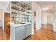 Stylish bar area with mirrored shelving, sink, and cabinets, connecting to other rooms at 8977 E Ludlow Dr, Scottsdale, AZ 85260
