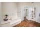 Bright bathroom featuring a soaking tub, an open doorway to the shower, and wood-look floors at 8977 E Ludlow Dr, Scottsdale, AZ 85260