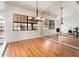 Dining room with wood floors, large windows, mirrored wall, and modern chandelier at 8977 E Ludlow Dr, Scottsdale, AZ 85260