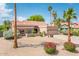 Inviting single-story home with desert landscaping, rocks, mature palm trees, and a two-car garage at 8977 E Ludlow Dr, Scottsdale, AZ 85260
