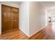 Hallway featuring a built-in wood closet, wood-look floors, and a view to the bedroom at 8977 E Ludlow Dr, Scottsdale, AZ 85260
