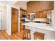 Traditional kitchen with oak cabinetry, stainless steel appliances, and breakfast bar with white countertops at 8977 E Ludlow Dr, Scottsdale, AZ 85260