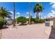 Gravel backyard featuring palm trees, grass, landscaping, and patio furniture at 9302 E Broadway Rd # 45, Mesa, AZ 85208