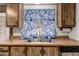 Close up of a double basin sink and blue leafy curtains in the kitchen at 9302 E Broadway Rd # 45, Mesa, AZ 85208
