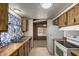 Galley-style kitchen featuring wood cabinets, double basin sink, and white appliances at 9302 E Broadway Rd # 45, Mesa, AZ 85208