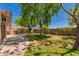 A backyard with a brick paved sidewalk, grass, trees, a brick wall, and a wood fence at 9603 N 1St Ave, Phoenix, AZ 85021
