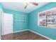 Bright bedroom with aqua walls, wood-look floors, open shelving, and a window for plenty of natural light at 9603 N 1St Ave, Phoenix, AZ 85021