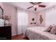 This bedroom boasts a ceiling fan, pink walls, and a bed with decorative pillows at 9603 N 1St Ave, Phoenix, AZ 85021