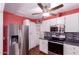 This kitchen features stainless appliances, white cabinetry, mosaic backsplash, and a ceiling fan at 9603 N 1St Ave, Phoenix, AZ 85021