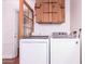 Laundry room with washer, dryer, and a wooden storage cabinet above appliances at 9603 N 1St Ave, Phoenix, AZ 85021