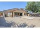 Spacious backyard showcasing neutral tones, a covered patio, and low-maintenance desert landscaping at 1026 E Julie Ave, San Tan Valley, AZ 85140