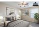 Staged bedroom featuring neutral tones, carpet, modern artwork, and a ceiling fan at 1026 E Julie Ave, San Tan Valley, AZ 85140