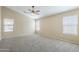Carpeted bedroom features a ceiling fan and bright, natural light from multiple windows at 1026 E Julie Ave, San Tan Valley, AZ 85140