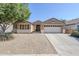 Exterior of tan single-story home featuring drought-resistant landscaping, and a two car garage at 1026 E Julie Ave, San Tan Valley, AZ 85140