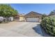 Exterior of a tan, single-story home featuring drought-resistant landscaping, and a two-car garage at 1026 E Julie Ave, San Tan Valley, AZ 85140