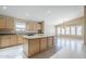 Bright kitchen with neutral cabinets, granite countertops, and a spacious central island for food preparation and storage at 1026 E Julie Ave, San Tan Valley, AZ 85140