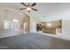 Spacious living room with open layout to the kitchen, neutral paint and ceiling fan at 1026 E Julie Ave, San Tan Valley, AZ 85140