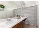 Bathroom with long vanity, a large mirror, and a shower with a striped curtain at 1130 E Ferrara St, San Tan Valley, AZ 85140