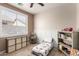 Bedroom with window, neutral walls, and a bookshelf filled with books and decorative items at 1130 E Ferrara St, San Tan Valley, AZ 85140