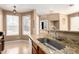 Well-lit kitchen sink with granite countertops and wooden cabinetry at 1130 E Ferrara St, San Tan Valley, AZ 85140