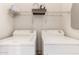 Functional laundry room with a wire shelf, a stack of clothes, and ironing board at 1130 E Ferrara St, San Tan Valley, AZ 85140