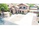 Aerial view of a well-maintained two-story home, desert landscaping, and expansive concrete driveway at 11419 E Ellis St, Mesa, AZ 85207