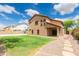 Spacious backyard with grass, a covered patio, and decorative rock landscaping at 11419 E Ellis St, Mesa, AZ 85207