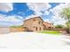 Concrete backyard with storage shed and a partial lawn under a partly cloudy sky at 11419 E Ellis St, Mesa, AZ 85207