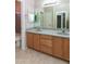 This bathroom features a double sink vanity with granite countertops and wood cabinets at 11419 E Ellis St, Mesa, AZ 85207