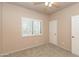 Bright bedroom features neutral walls, ceiling fan, carpet flooring, and shuttered window at 11419 E Ellis St, Mesa, AZ 85207