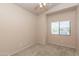 Cozy bedroom with neutral walls, carpet, ceiling fan, and a window with a view at 11419 E Ellis St, Mesa, AZ 85207