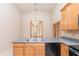 Kitchen view with stainless steel dishwasher and sink, wood cabinets, granite countertops, and shuttered windows at 11419 E Ellis St, Mesa, AZ 85207