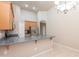 Open kitchen with stainless steel refrigerator, wood cabinets, breakfast bar, and an adjacent dining area at 11419 E Ellis St, Mesa, AZ 85207