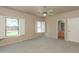 Spacious main bedroom featuring neutral colors, two windows, ceiling fan and an ensuite bathroom at 11419 E Ellis St, Mesa, AZ 85207