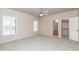 Spacious bedroom with carpet flooring, ceiling fan, and windows with plantation shutters at 11419 E Ellis St, Mesa, AZ 85207