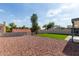 Wide backyard with artificial grass area, hardscape, and a rock landscape at 1421 E Charleston Ave, Phoenix, AZ 85022
