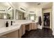 Beautiful primary bathroom features double sink vanity, hexagon tile floor and access to walk-in closet at 1421 E Charleston Ave, Phoenix, AZ 85022