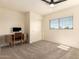 Well-lit bedroom featuring a ceiling fan, plush carpet, and a functional desk area at 1421 E Charleston Ave, Phoenix, AZ 85022