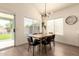 Bright dining room with modern light fixture, table with seating, and sliding glass doors leading to the backyard at 1421 E Charleston Ave, Phoenix, AZ 85022