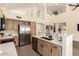 Open-concept kitchen with stainless steel appliances, light wood cabinets, and white countertops at 1421 E Charleston Ave, Phoenix, AZ 85022