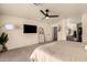 Bright main bedroom with carpet, ceiling fan, large window and access to the ensuite bathroom and walk-in closet at 1421 E Charleston Ave, Phoenix, AZ 85022