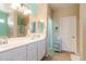 Bright bathroom features a double sink vanity with white cabinets, framed mirrors, and separate tub and shower at 1461 W Brangus Way, San Tan Valley, AZ 85143
