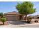 Exterior view of home with desert landscaping and mature shade tree at 1461 W Brangus Way, San Tan Valley, AZ 85143