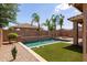 Backyard oasis with a sparkling pool, lush landscaping, and an inviting fire pit area at 1461 W Brangus Way, San Tan Valley, AZ 85143