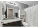 Well-lit bathroom featuring a granite countertop, white cabinets, and a decorative shower curtain at 15453 W Shangri La Rd, Surprise, AZ 85379